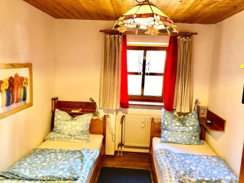 um pequeno quarto com 2 camas e uma janela em SIMPLY-THE-BEST-Ferienwohnung-mit-Pool-Sauna-Schwimmbad-bis-6-Personen em Hauzenberg