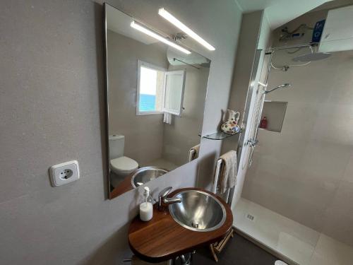 a bathroom with a sink and a mirror at Apartamento en acantilado con wifi y aire acondicionado in Sitges