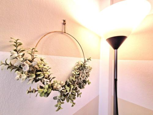 ein Kranz hängt an einer Wand neben einer Lampe in der Unterkunft Puccio Home Stadio - City Center in Verona
