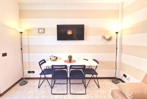 ein Esszimmer mit einem Tisch und Stühlen sowie einem TV in der Unterkunft Puccio Home Stadio - City Center in Verona