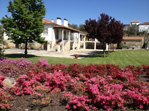 a garden with pink flowers in front of a house at Casa do Rocio in Várzea de Abrunhais