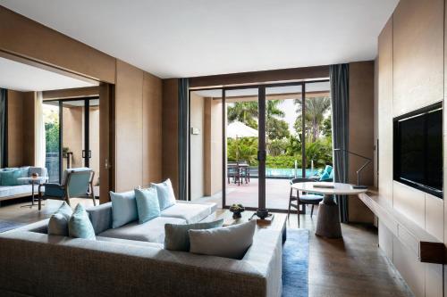 a living room with a couch and a tv at Xiamen Marriott Hotel & Conference Centre in Xiamen