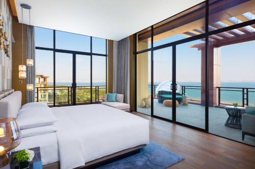 a bedroom with a white bed and a view of the ocean at Xiamen Marriott Hotel & Conference Centre in Xiamen