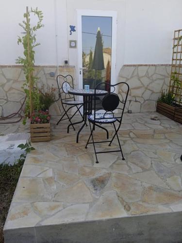 a patio with two chairs and a table on a stone patio at La Rana Azul in Vélez-Málaga