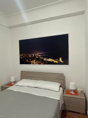 1 dormitorio con 1 cama con una foto en la pared en Sissi House Salerno, en Salerno