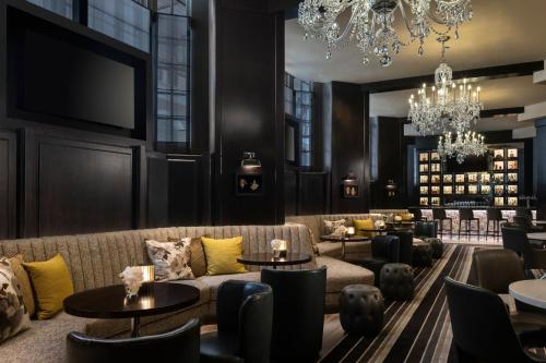a hotel lobby with a couch and tables and a chandelier at The Ritz-Carlton Atlanta in Atlanta