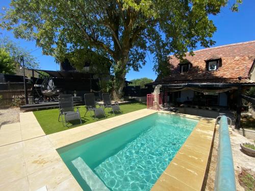 une piscine dans l'arrière-cour d'une maison dans l'établissement Charme rustique- piscine privée et jardin, à Queyssac