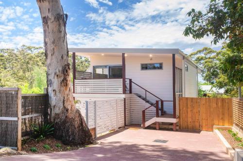 a house with a staircase next to a tree at Karri Tree Studio Apartment in Margaret River Town