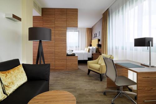 a living room with a couch and a desk at Bonn Marriott Hotel in Bonn