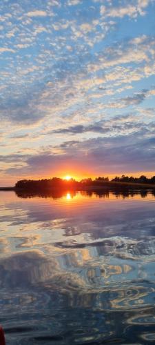 a reflection of the sun in the water at sunset at Gościniec Joanna in Rajgród