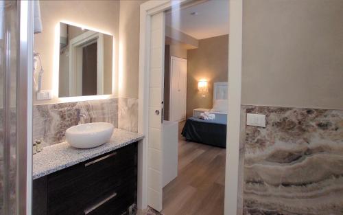 La salle de bains est pourvue d'un lavabo et d'un miroir. dans l'établissement Hotel Cecina Beach, à Marina di Cecina