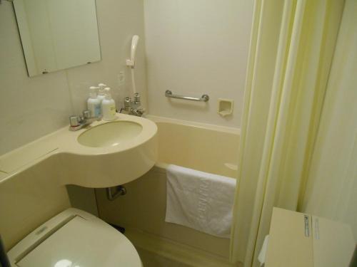 een kleine badkamer met een wastafel en een toilet bij Grand Central Hotel in Tokyo