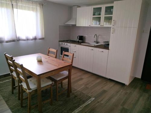 Apartman Srna - Gorski kotar في Sunger: مطبخ مع طاولة خشبية وطاولة وكراسي