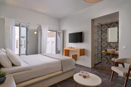 a bedroom with a bed and a living room at Meltemi Village Hotel in Perissa