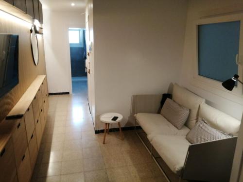 a living room with a white couch and a television at 2 bedroom large modern apartment in Blanes Old Town 50m from the beach! in Blanes