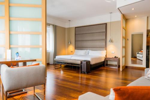 um quarto de hotel com uma cama e um sofá em Hotel Compostela em Santiago de Compostela