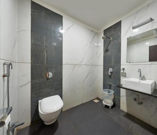 a bathroom with a toilet and a sink at Hotel Fortune Inn in Kolhapur