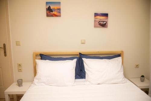a bedroom with a bed with three pictures on the wall at Odysseas Home Kalamata in Kalamata