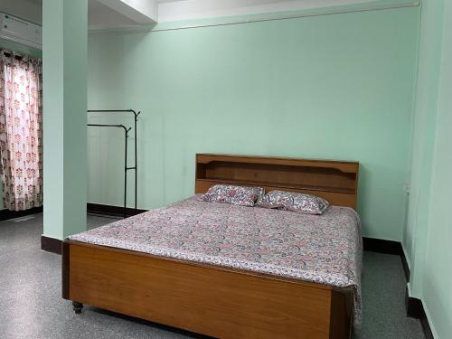 - une chambre avec un lit en bois et des oreillers dans l'établissement Nyla homestay Naharlagun, à Bacha