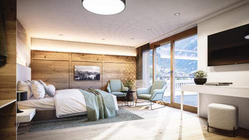 a bedroom with a bed and two chairs and a desk at Leni Mountain Lodge in Sölden