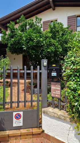 a fence with a sign in front of a building at Elisa Holidays in Puegnano del Garda