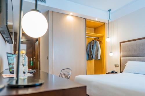 a hotel room with a bed and a desk and a bedroom at Hotel Compostela in Santiago de Compostela