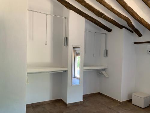 a room with white walls and a window and shelves at Casa Genilla in Priego de Córdoba