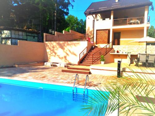 a house with a swimming pool in front of a house at Villa Hani in Sarajevo