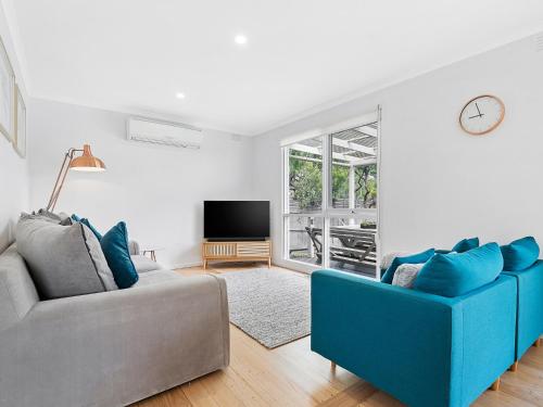 a living room with two blue chairs and a tv at Rye Beach And Pool House by Ready Set Stay in Rye