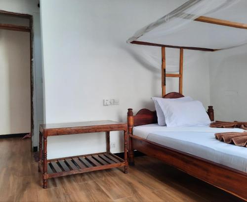 a bedroom with two beds and a wooden floor at Kajificheni House in Nungwi