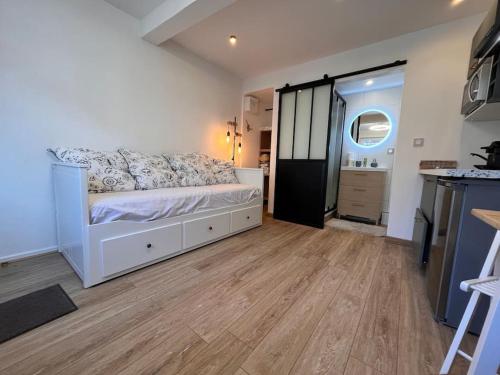 une chambre avec un lit blanc et un parquet dans l'établissement Studio « Le petit Prat », à Colomiers