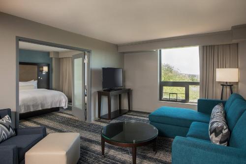 une chambre d'hôtel avec un lit et un canapé bleu dans l'établissement Boston Marriott Burlington, à Burlington