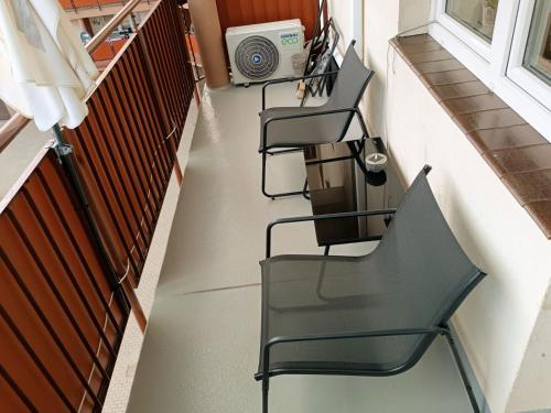 una escalera con sillas negras y una ventana en Apartament comfort, en Pisz