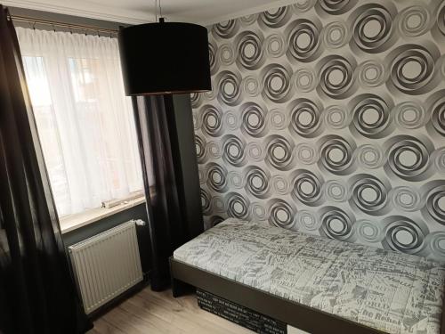 a bedroom with a swirl pattern on the wall at Apartament comfort in Pisz