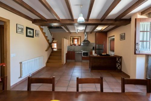uma sala de estar com uma mesa e uma cozinha em Casa rural completa Río Sarela em Santiago de Compostela