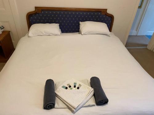 a bed with a bag on it with two pillows at The Royal Victoria & Bull Hotel in Rochester
