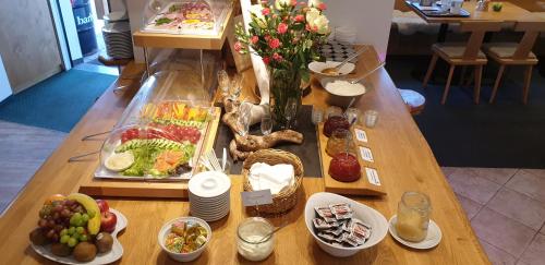 オフターシュヴァングにあるLandhotel Alphornの食べ物の皿が置かれた木製のテーブル