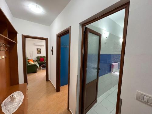 um corredor com duas portas de vidro e um corredor com uma sala de estar em Leo Apartment em Përmet