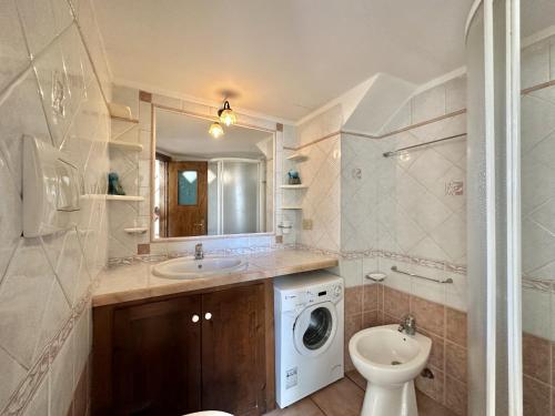 een badkamer met een wastafel en een wasmachine bij Holidaycasa Lavinia - Luxury Sperlonga Suite in Sperlonga