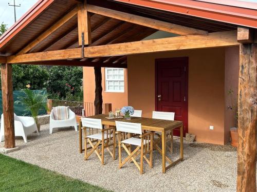 a wooden table and chairs under a wooden pergola at Casa da Vila em Celorico de Basto in Celorico de Basto