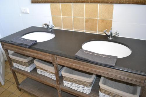 dois lavatórios num balcão preto numa casa de banho em Louisehoeve Holiday Home em Linschoten