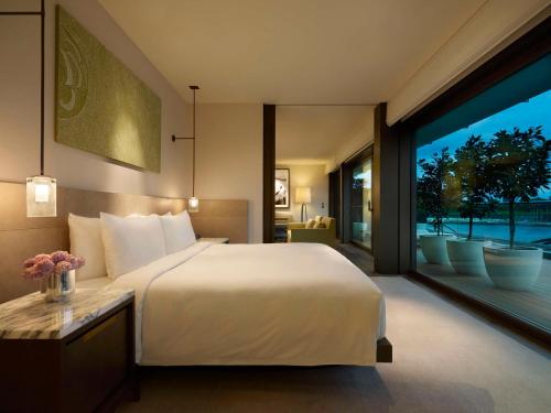 a bedroom with a large white bed and a large window at Park Hyatt Sydney in Sydney