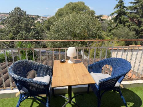 uma mesa com duas cadeiras e um candeeiro numa varanda em Chambre privée avec salle d’eau et terrasse au calme em Le Cannet