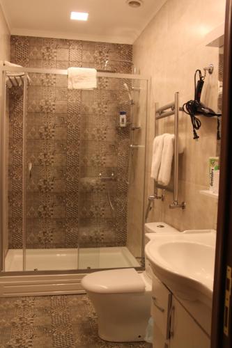 a bathroom with a shower and a toilet and a sink at Hotel 1883 in Baku