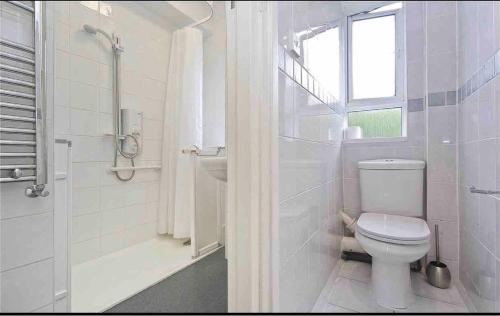 a white bathroom with a toilet and a window at London Single Rooms Female only Kings Cross Eurostar St Pancras International Station Camden Euston all nearby check in from 1230 PM till 3AM in London
