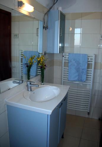 a white bathroom with a sink and a mirror at Mata Apartments in Premantura