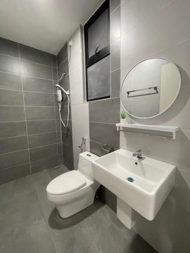 a bathroom with a toilet and a sink and a mirror at The Cove Duplex 13pax 3Br 4bathroom 2parking by IWH Suites in Ipoh