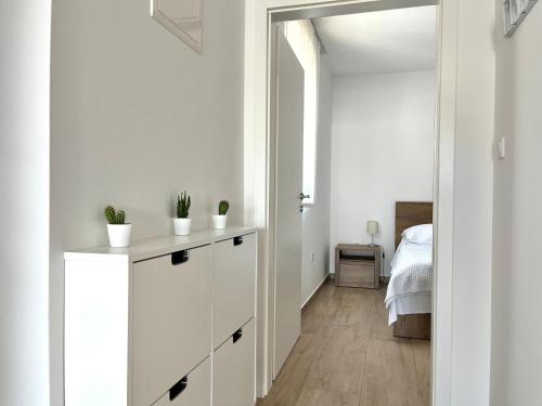 Ein weißes Zimmer mit einer weißen Kommode und einem Schlafzimmer. in der Unterkunft Katarina in Primošten