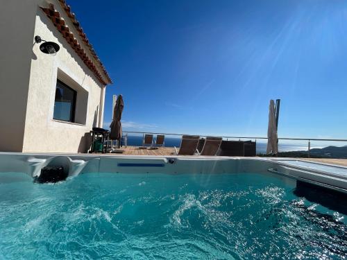 a pool of water with chairs and a house at Villa 4 Etoiles vue sur les Iles d'Or Carqueiranne Sea and Mountain Pleasure Villa vue mer 180 in Carqueiranne
