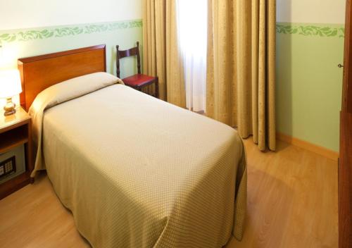 a bedroom with a bed and a table and a window at Hotel Terminus & Plaza in Pisa